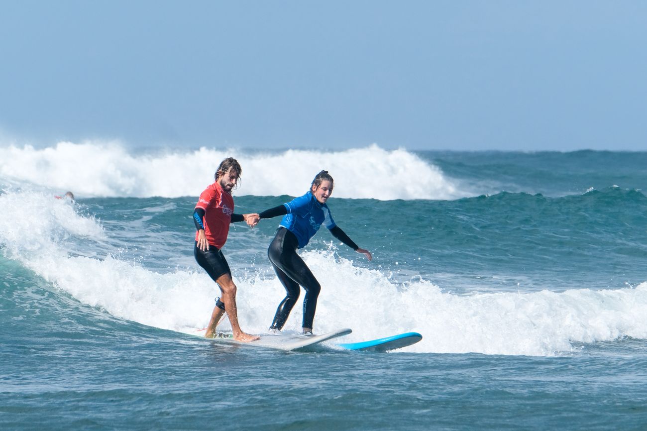 Instruktor i polaznica na talasu tokom surf časa